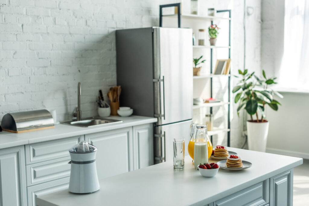 interior of modern light kitchen with fridge and kitchen counters