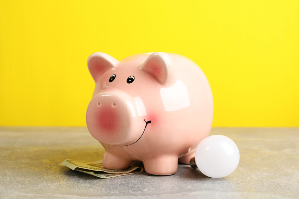 energy saving concept with piggy bank against yellow background